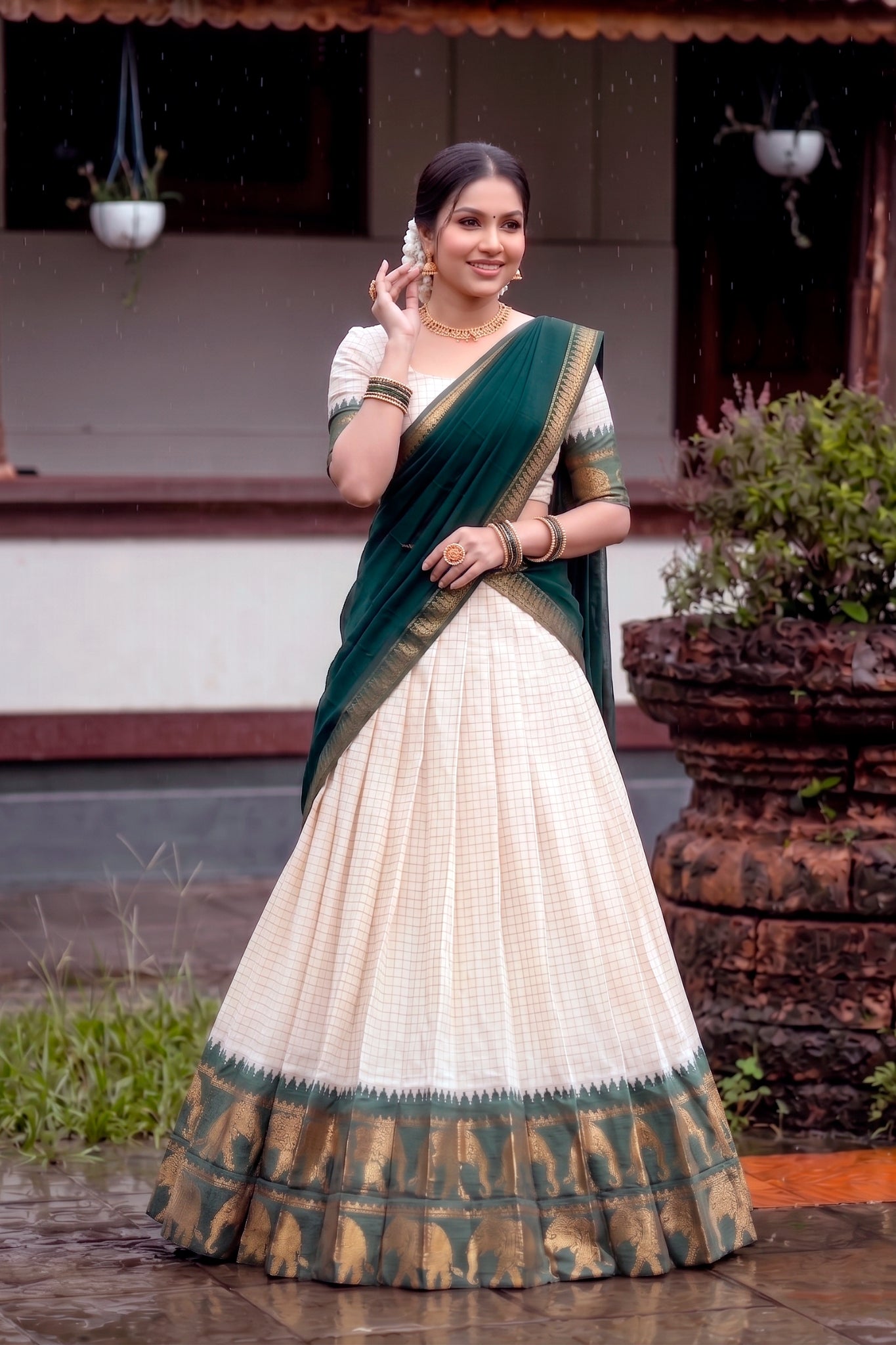 Woman in a green and white lehenga choli standing outdoors.