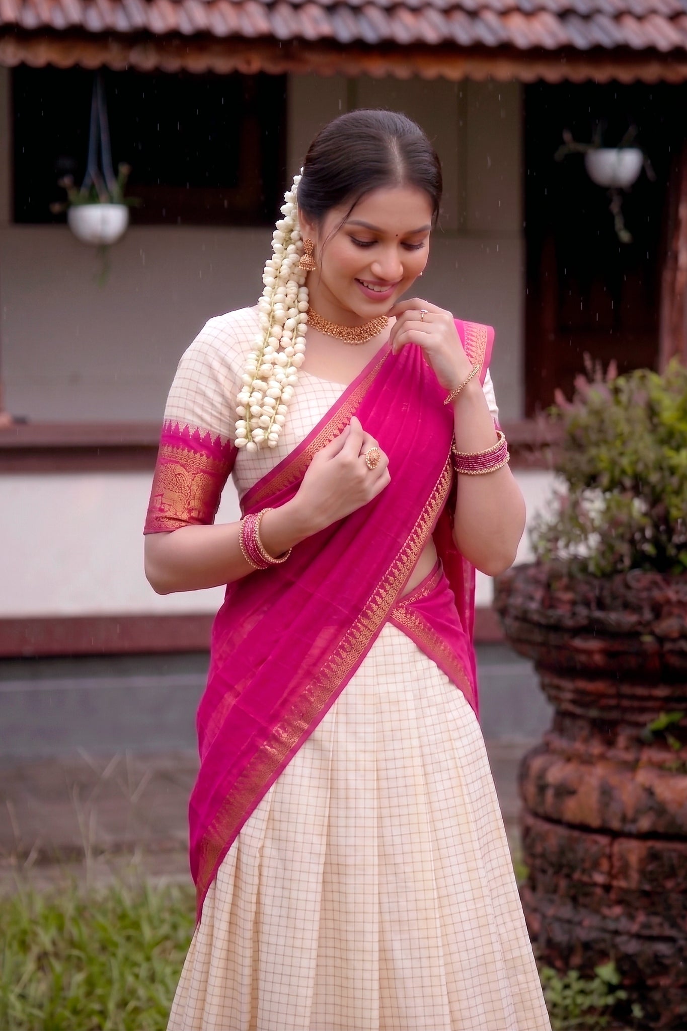 Woman in a pink and white lehenga choli standing outdoors