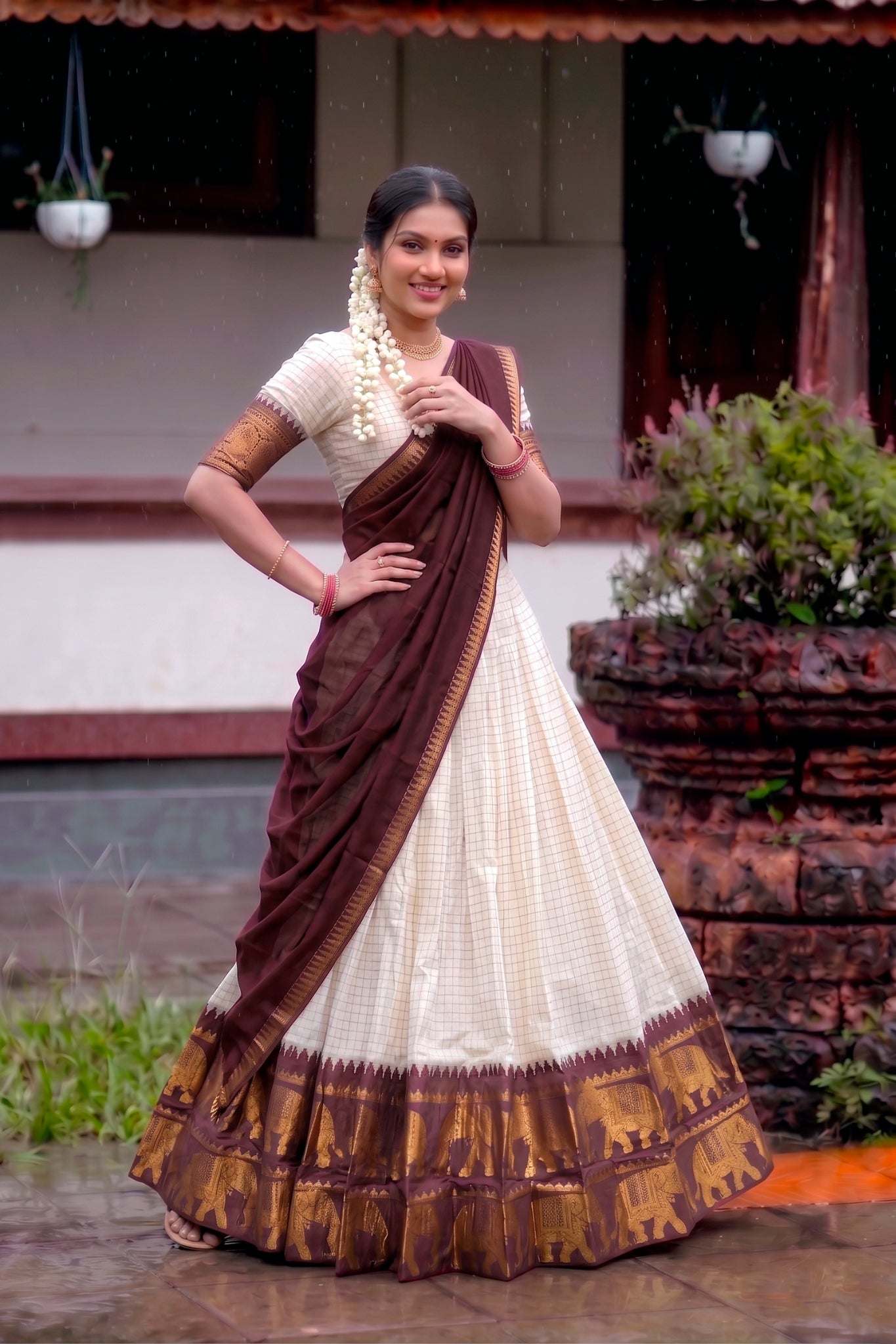 Woman wearing a traditional brown and white lehenga choli outdoors.