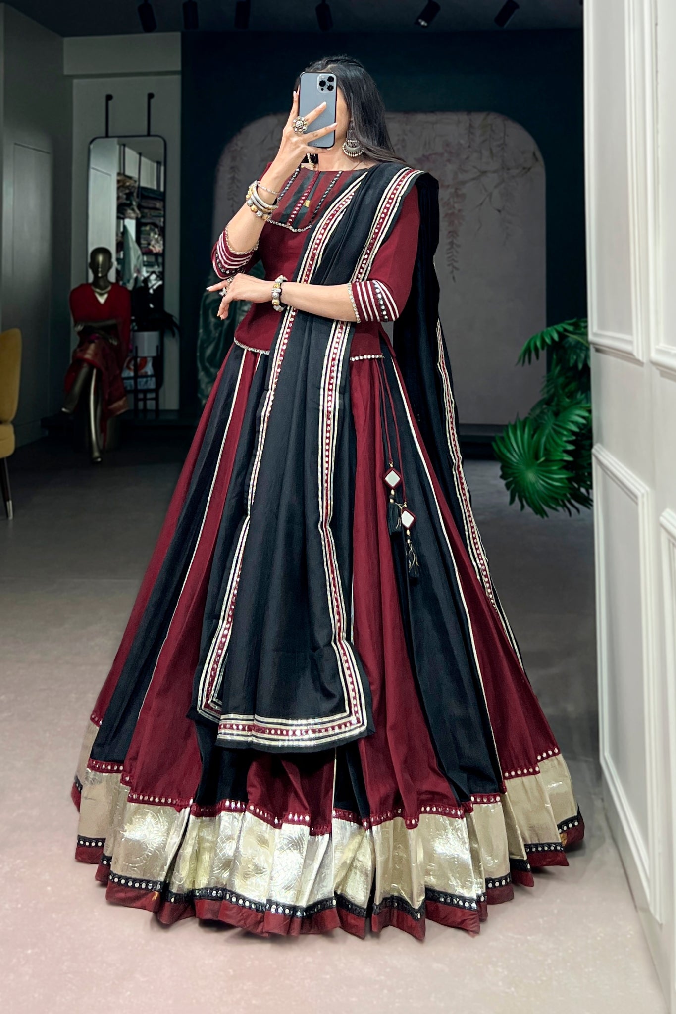 Woman wearing a traditional maroon and black navratri lehenga choli